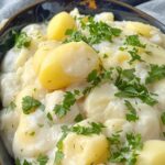 Creamy Victorian stewed potatoes garnished with fresh parsley in a rustic bowl